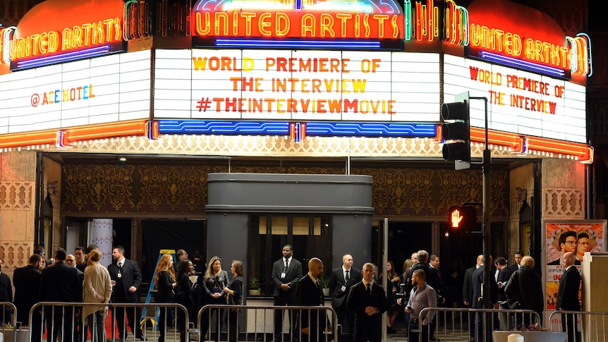 Security guards stand near the entrance of the United Artists theatre during the premiere of the film on December 11