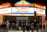 Security guards stand near the entrance of the United Artists theatre during the premiere of the film on December 11