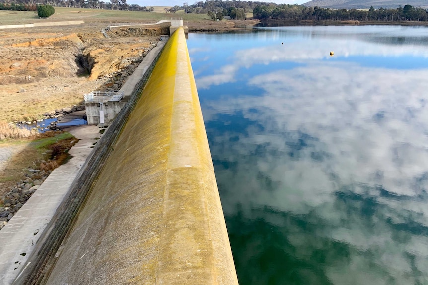 Man-made dam with cloud reflection.