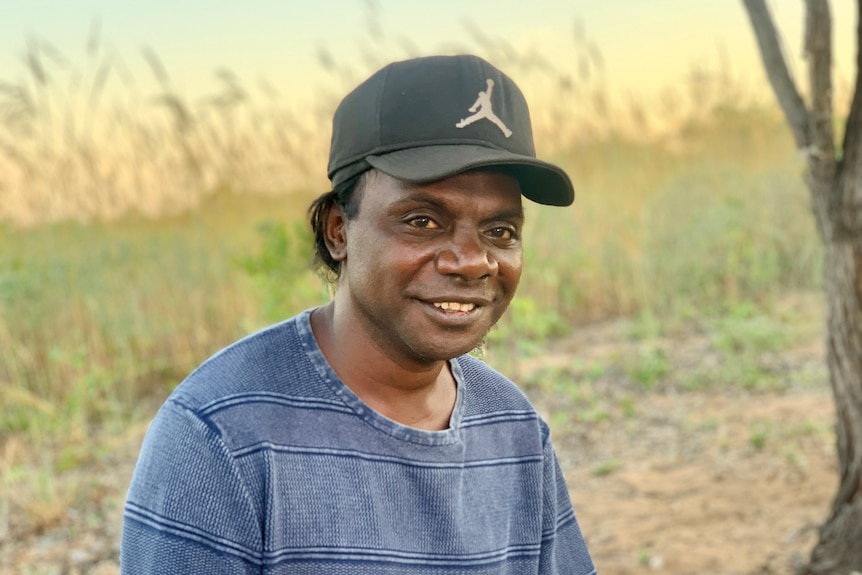 An Aboriginal man sitting outside.