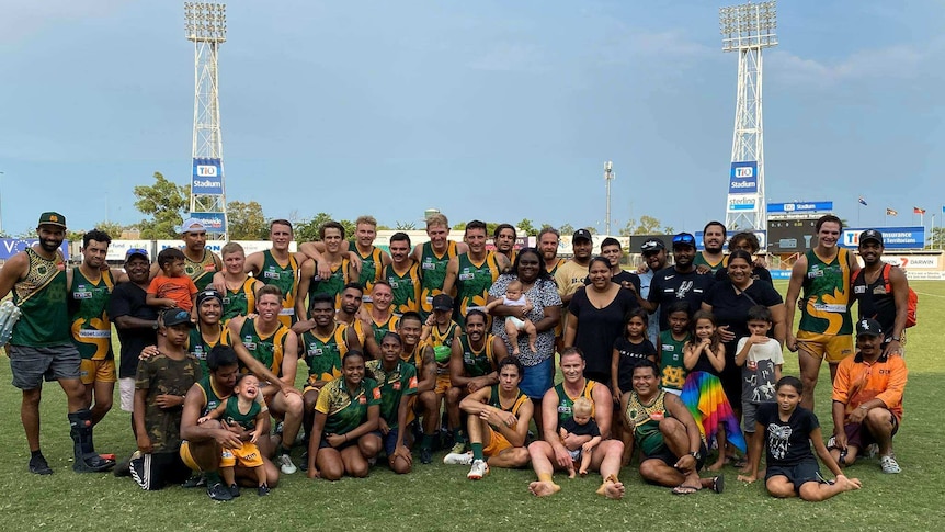 The Riioli family, many wearing St Mary's Football Club garments, are smiling together on an oval.