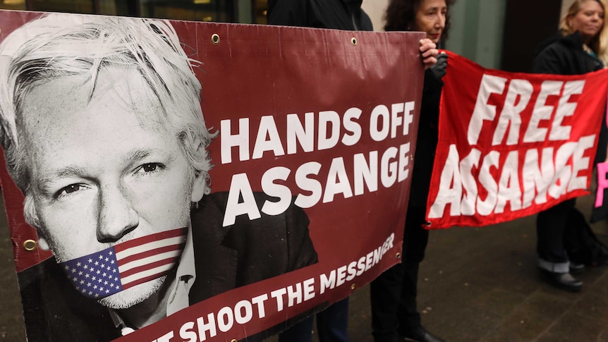 Demonstrators hold banners outside Westminster Magistrates Court in London.