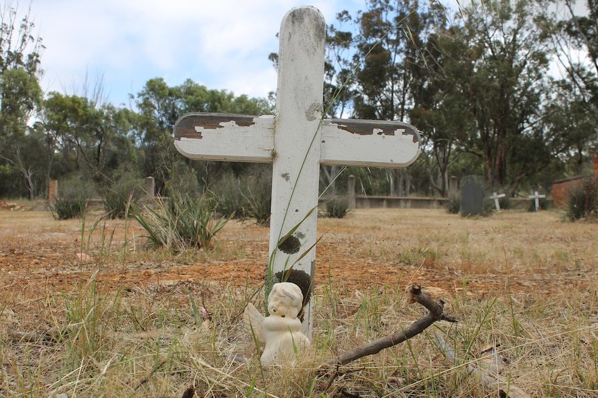 A white wooden cross in grave yard