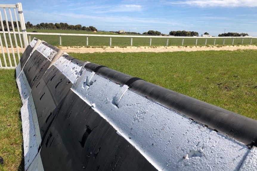 A black and white jumping hurdle made with foam.