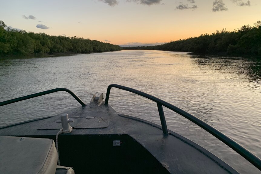 The front of a boat on the Proserpine River at sunset.
