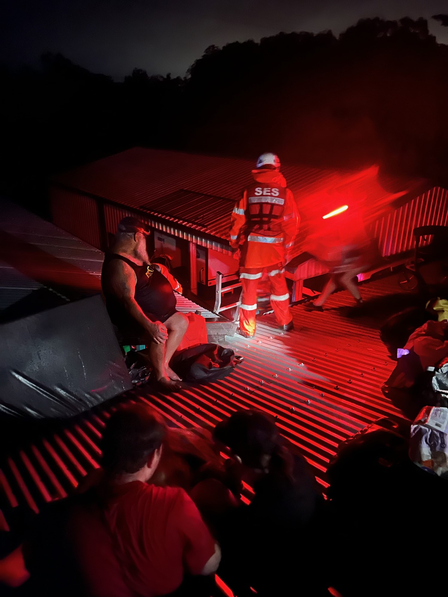 A group of people sitting on a tin roof at night