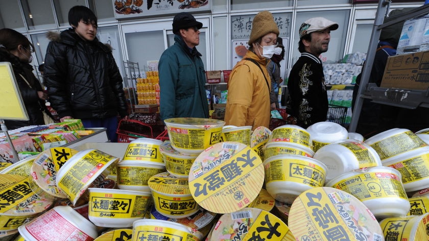 People queue for food at supermarket in Japan