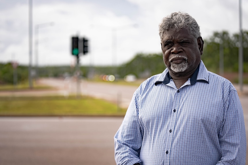 an aboriginal man wearing a blue collared shirt at an intersection