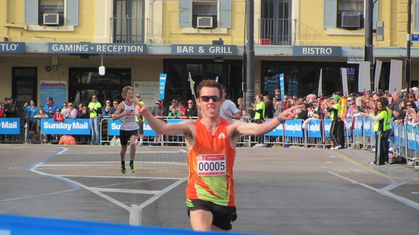 Runner crossing the City-Bay finish line