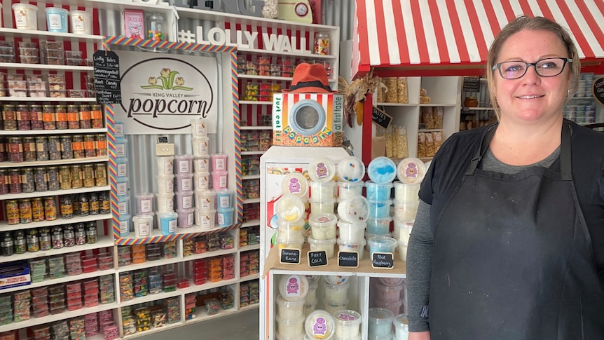 A smiling woman in glasses inside a shop