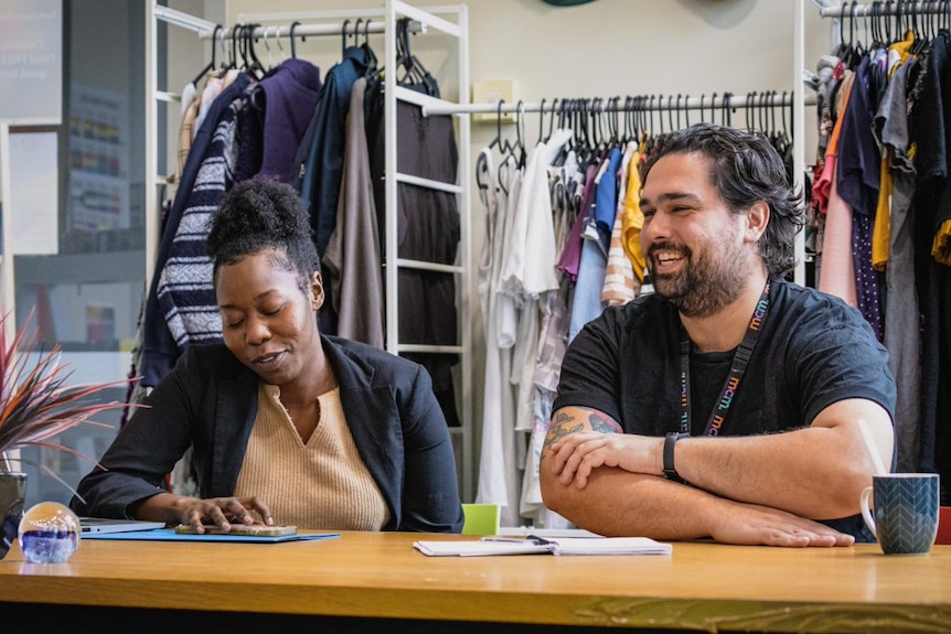 A woman and a man sitting at a table and laughing.