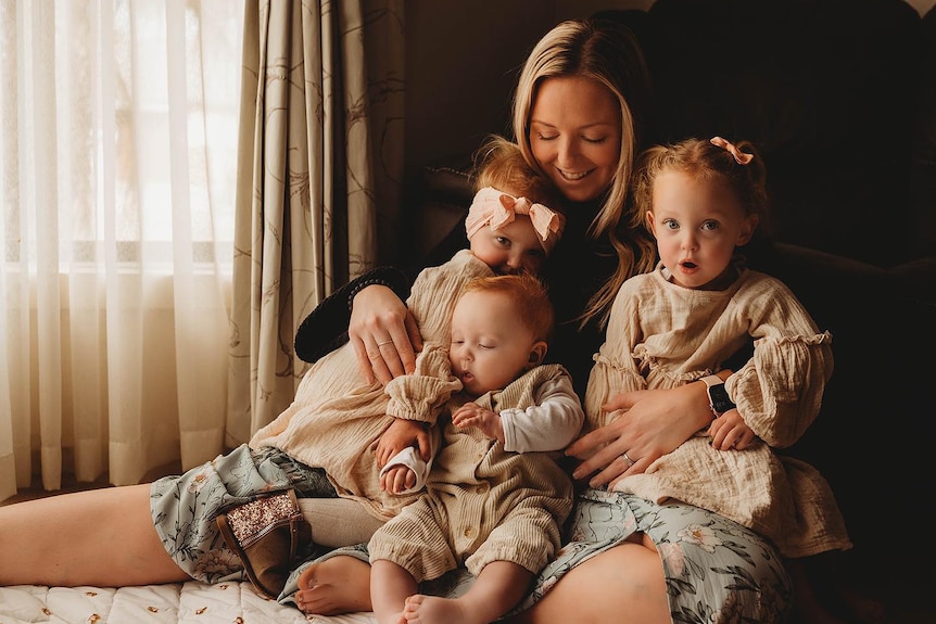 A woman with three young children