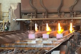 Beams of steel coming out of a furnace. 