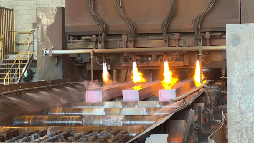 Beams of steel coming out of a furnace. 