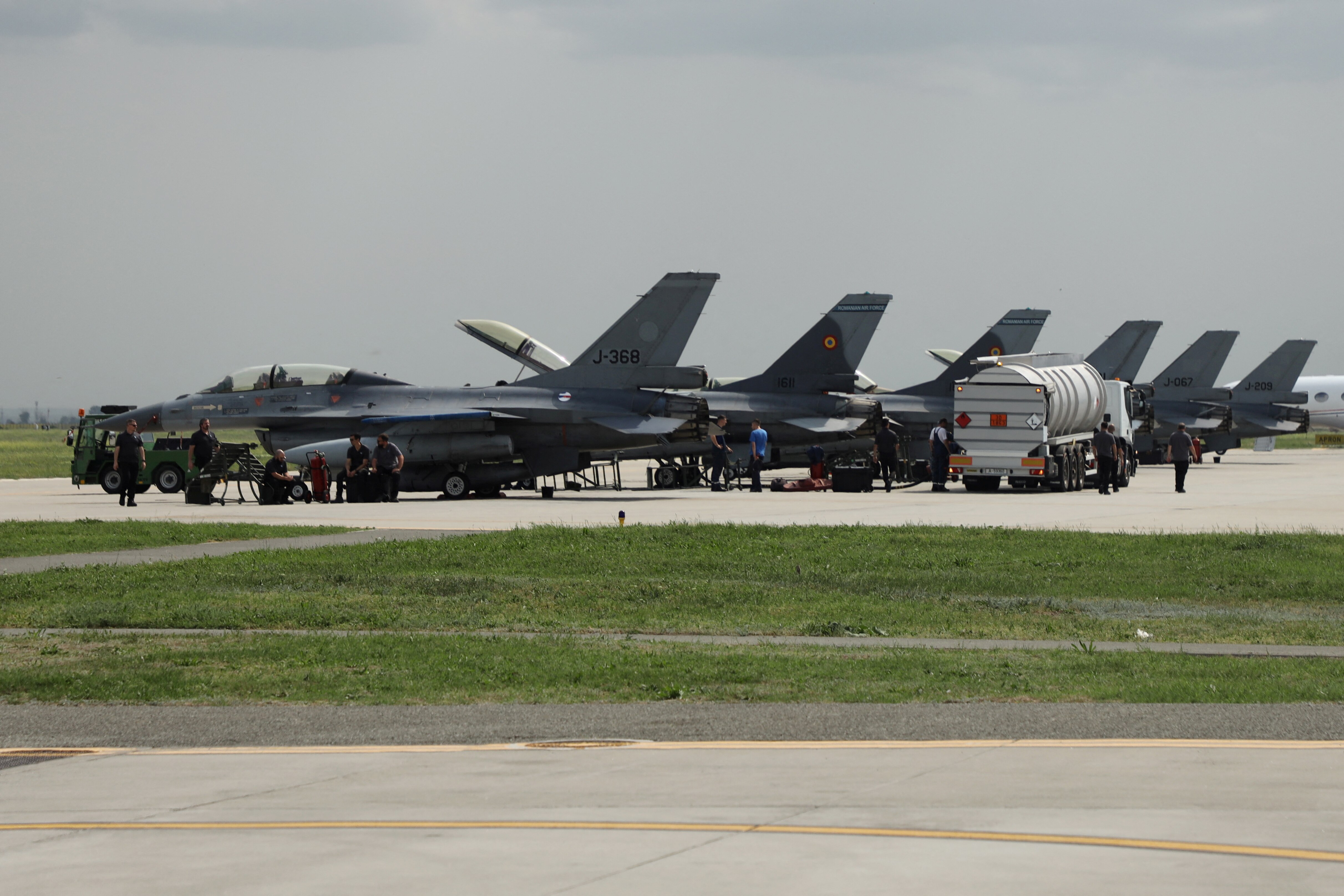 Six grey-coloured combat aircraft lined up at a hangar