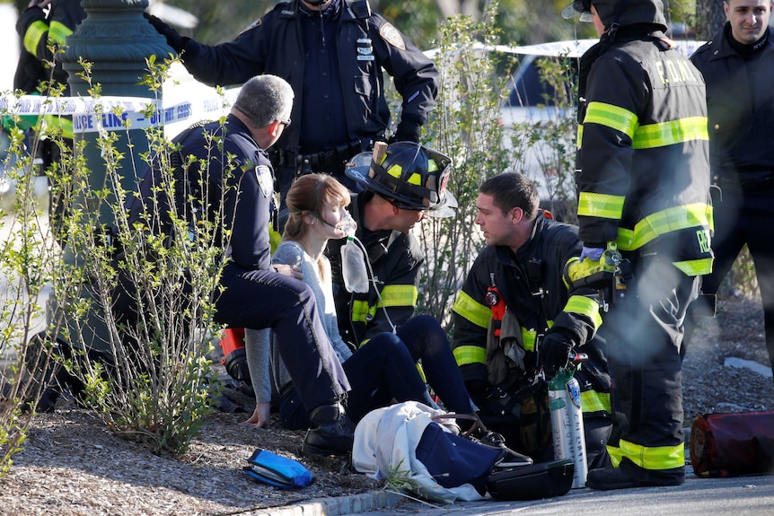 A woman is aided by first responders at the scene of an incident in lower Manhattan