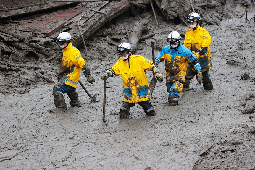 I soccorritori effettuano una ricerca nel luogo della frana di fango a Izusan, Atami