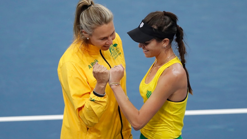 Alicia Molik and Ajla Tomljanovic bump fists on the court