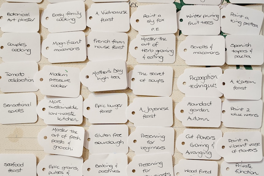 40 small labels with gardening and cooking classes written on them, pinned to a wall.