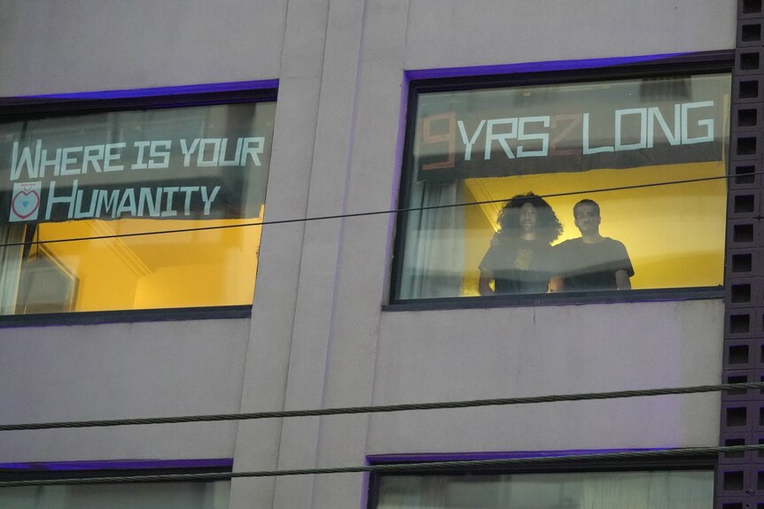 signs in window read where is your humanity and 9 years too long