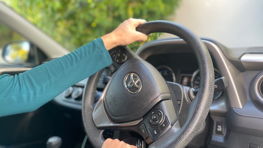 a woman hold the steering wheel of a car