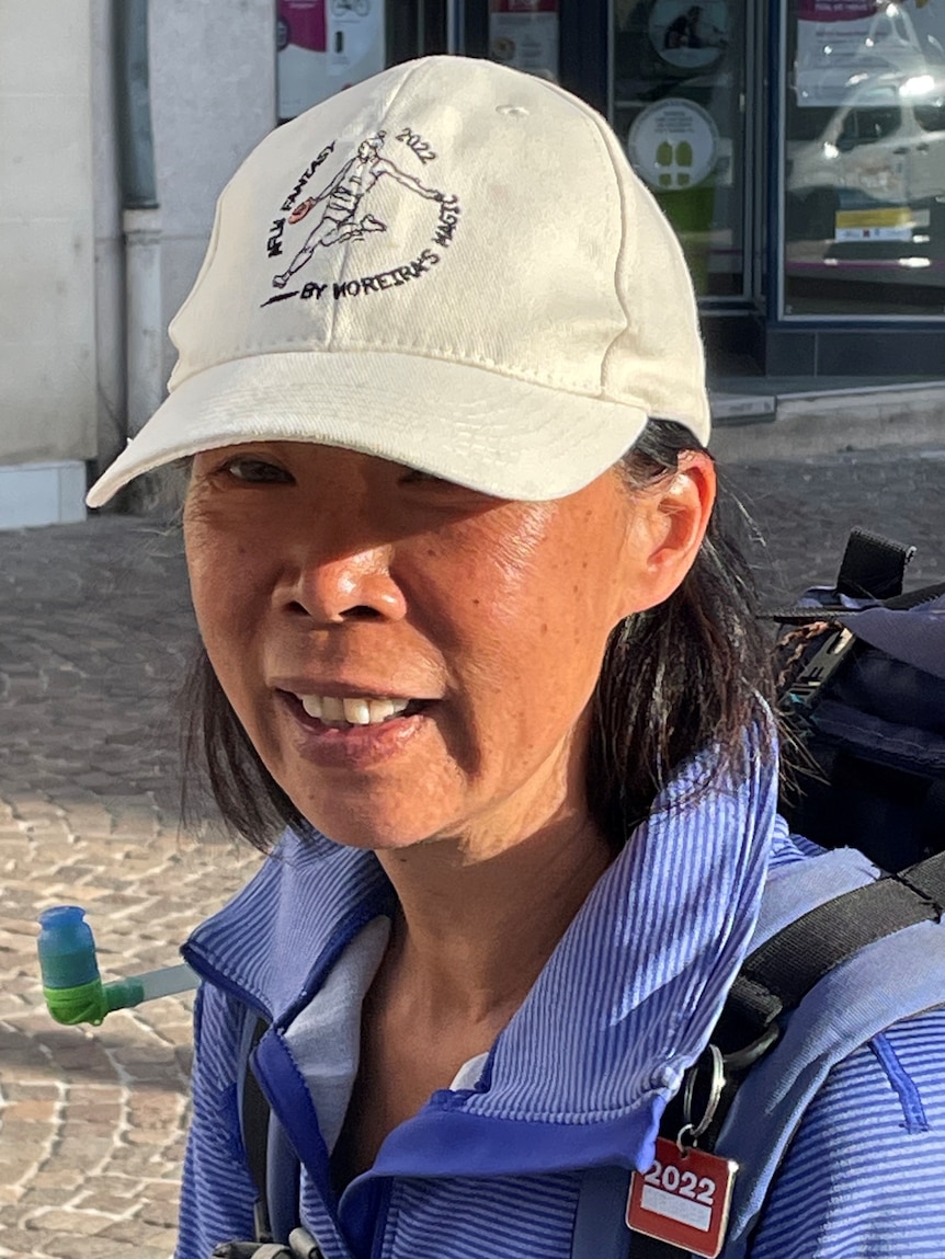 The Wongster is depicted wearing an AFLW fantasy hat and a backpack