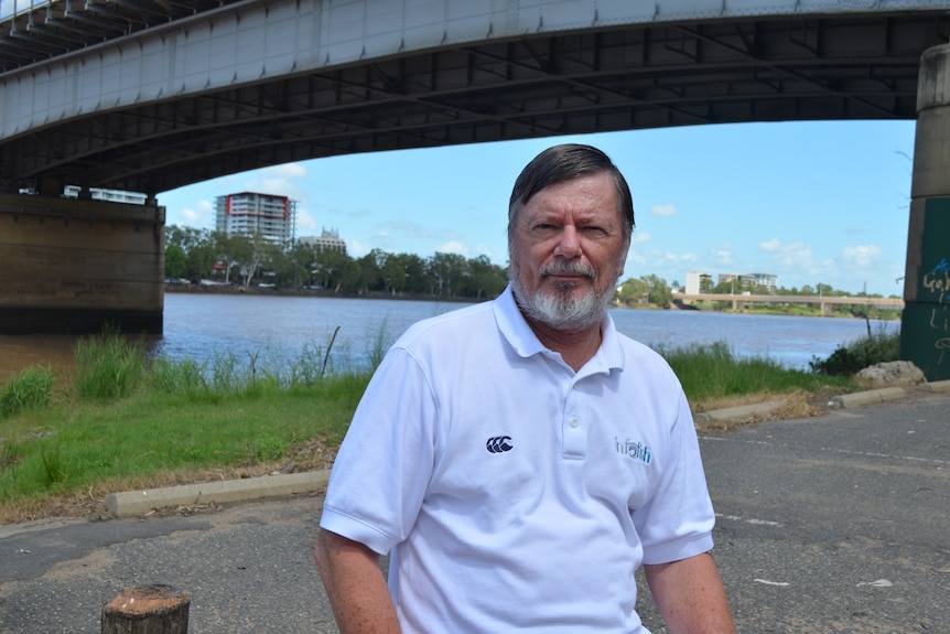 Bill Sawynock wearing a white t-shirt under a bridge.