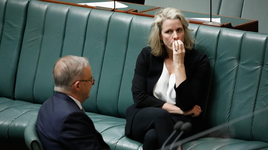 O'Neil has a concerned expression, hand to mouth, while she looks towards Albanese.