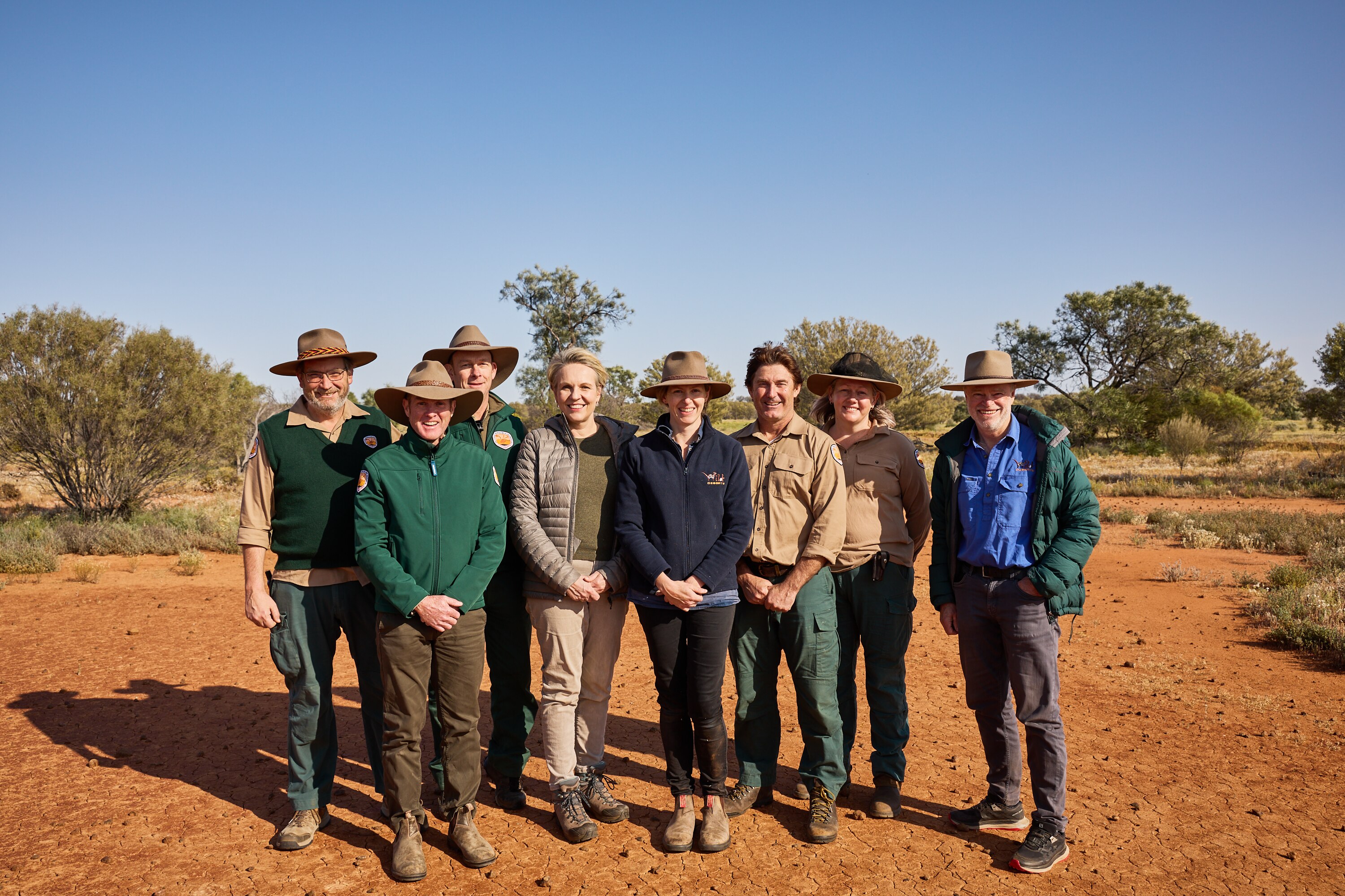 A group of people standing for a picture in a national park. 