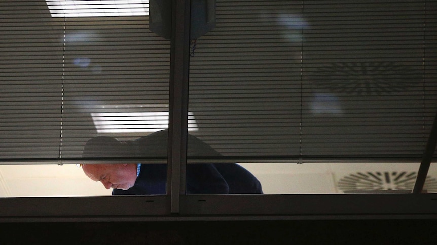 Man searches inside the offices of Cambridge Analytica in central London.