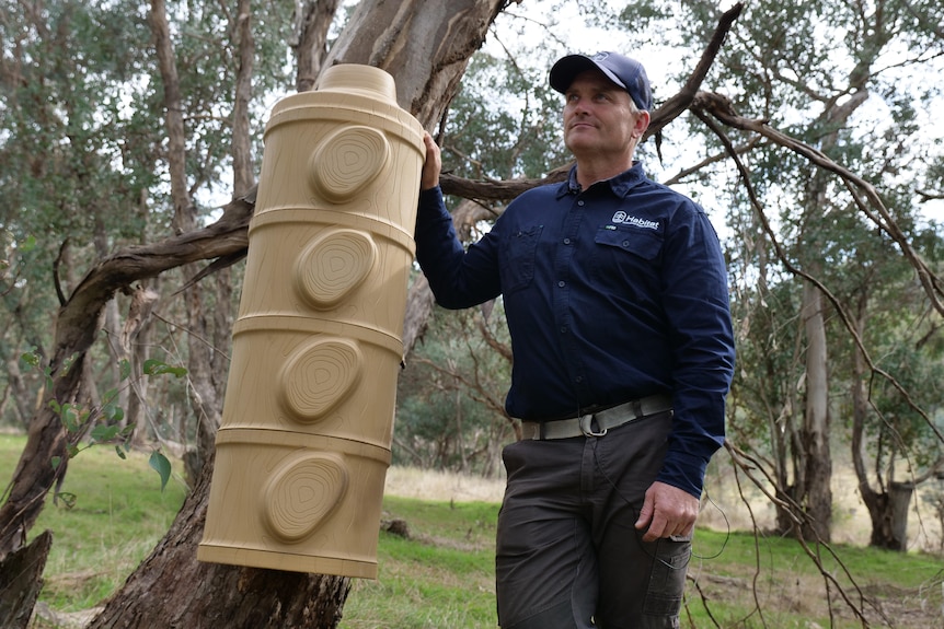 A man stands in front of a plastic nest box on a property in New South Wales.