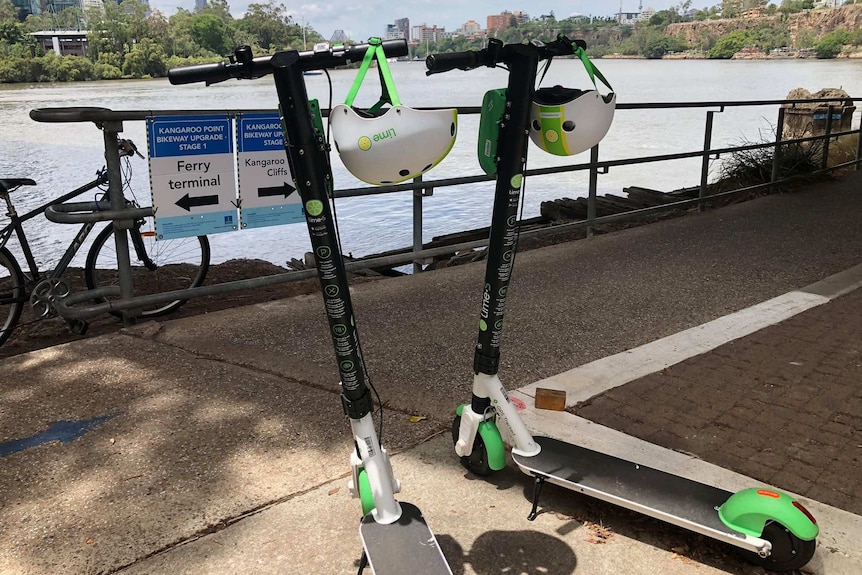 Two Lime scooters parked along the Brisbane River.