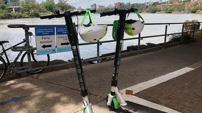 Two Lime scooters parked along the Brisbane River.