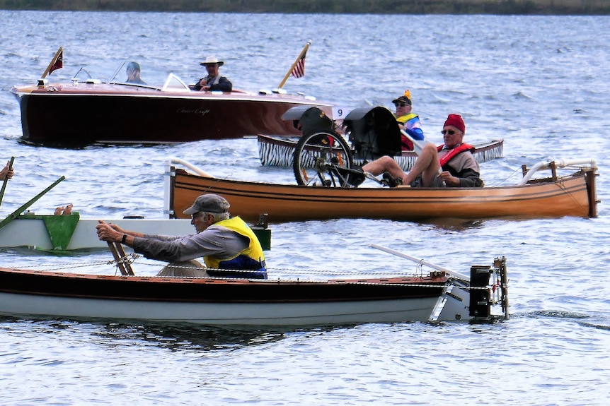 Members of the Cairns Wooden Boat Club in their boats competing in the Peculiar Propulsion Race on Lake Tinaroo.