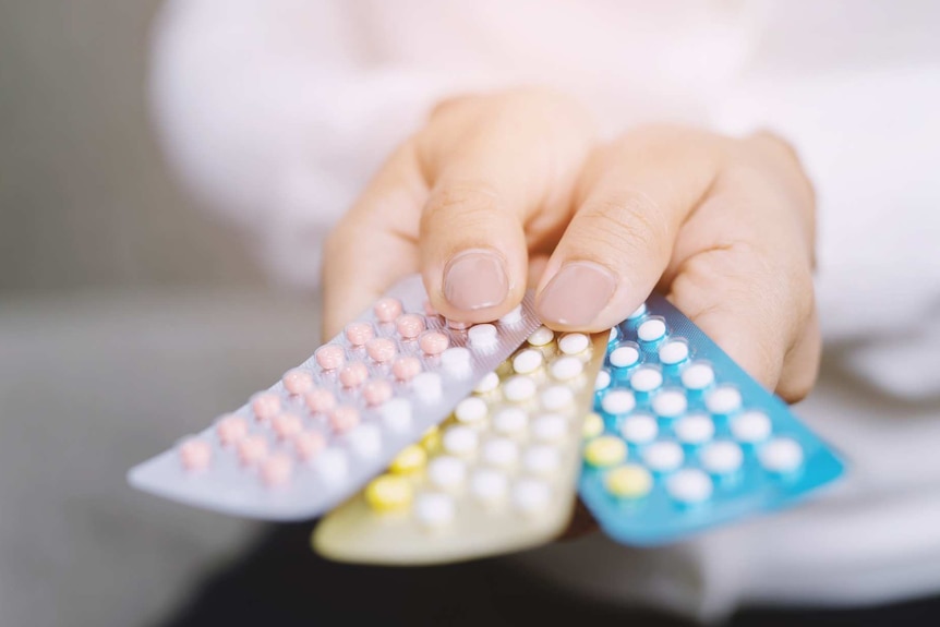 Woman holding packets of the contraceptive pill