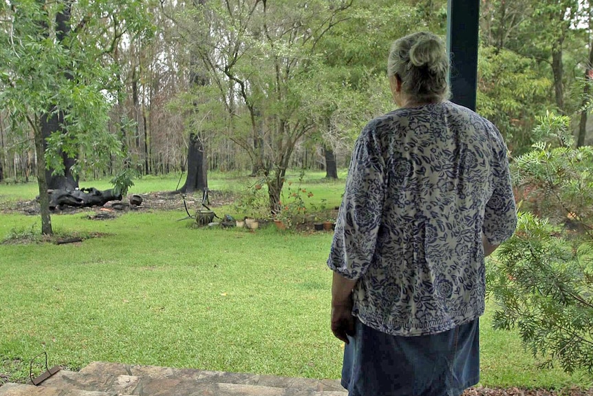 Daintry Garrand stands on her verandah looking at trees.