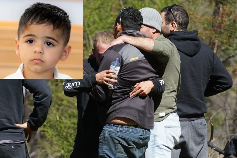 Father hugged by several men, photo of young boy in the top left corner.
