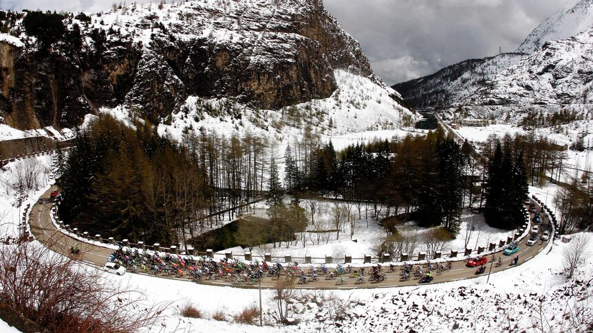 The peloton cycles through snow in the Giro d'Italia.