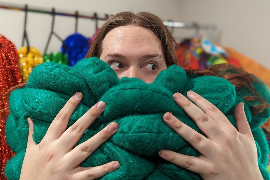 A person holding a handmade green creation.