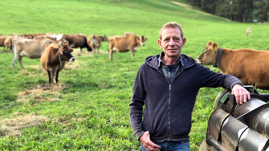Play Audio. Portrait of Paul Mumford leaning against a farm vehicle with Jersey dairy cattle and green grass in background.. Duration: 6 minutes 30 seconds