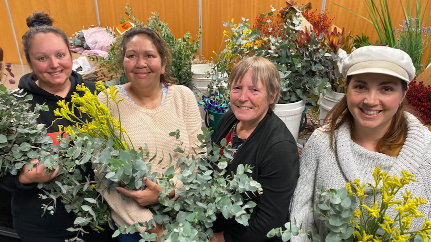 Four women holding flowers.