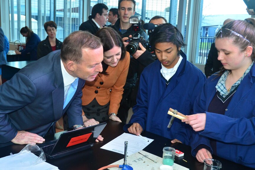 Prime Minister Tony Abbott is shown a science experiment by Newcomb Secondary College students.