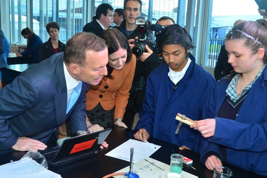 Prime Minister Tony Abbott is shown a science experiment by Newcomb Secondary College students.