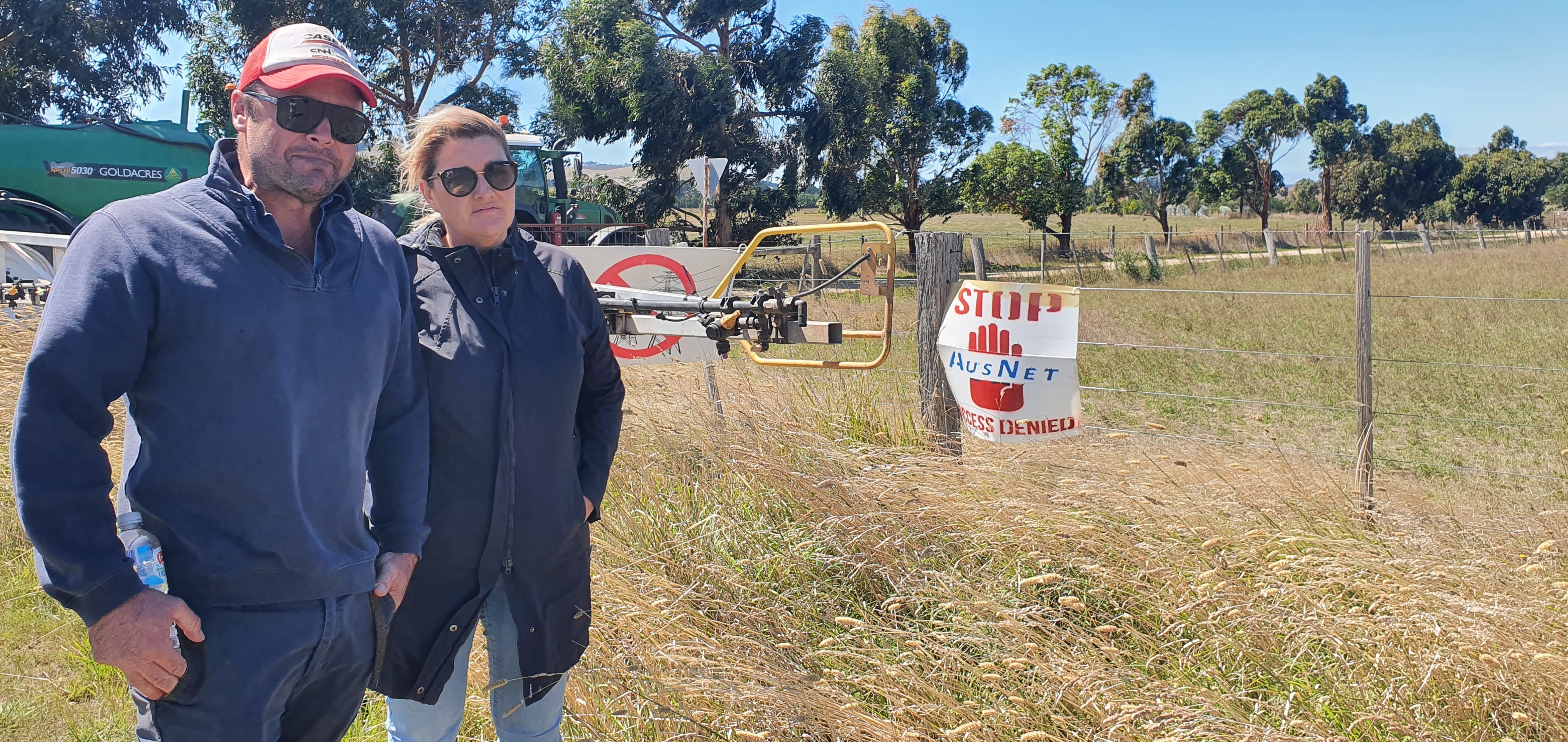 A man and a woman, looking angry as they stand in a paddock.