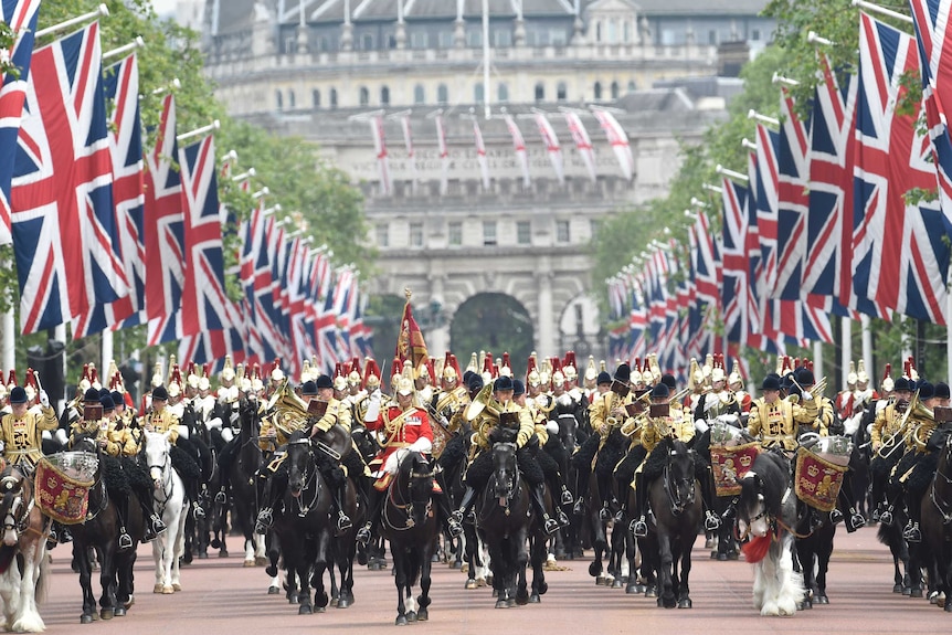 Guardsmen wearing gold, riding horses, arrive back at Buckingham Palace during the Queens 90th Birthday.