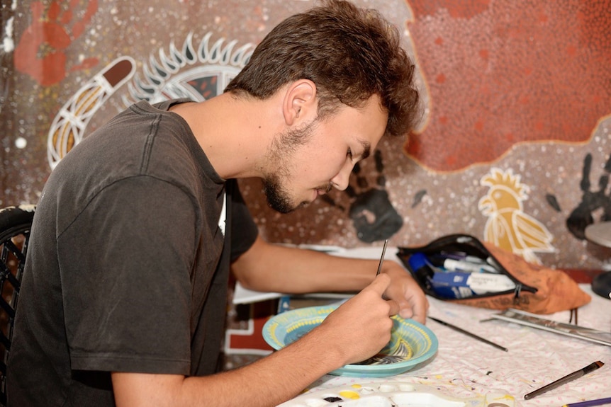 A young artist in Cherbourg works on one of his ceramic pieces