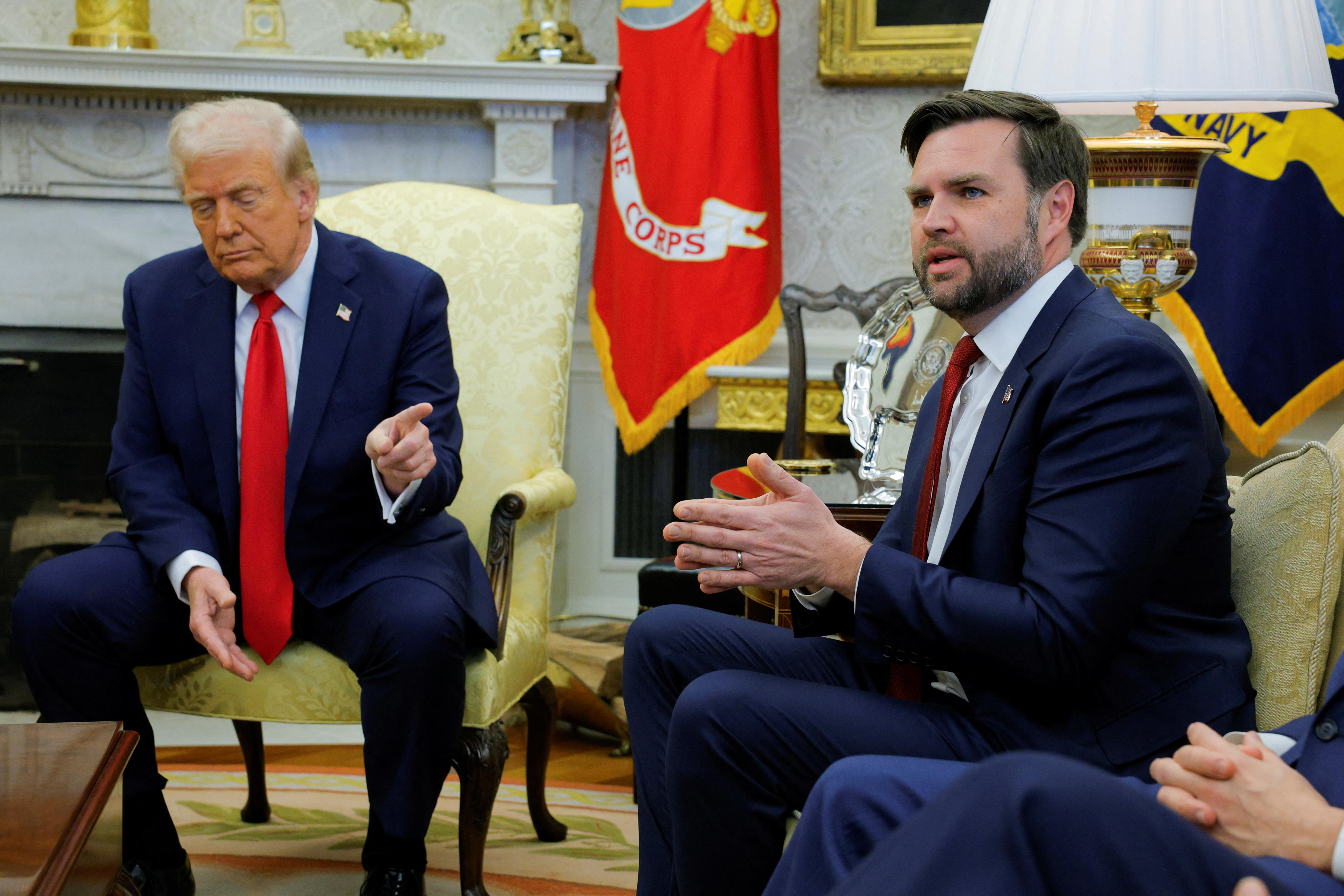 Donald Trump gestures next to JD Vance as they sit in the Oval Office.