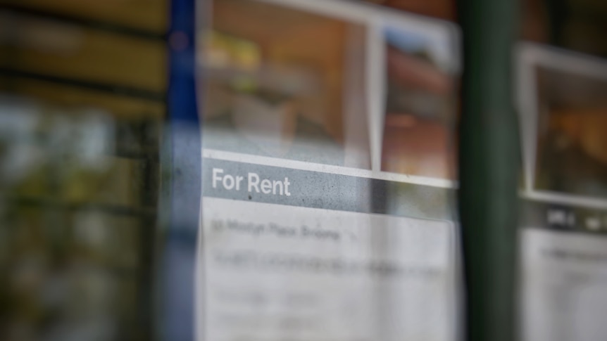 A blurred rental sign hanging in a window.
