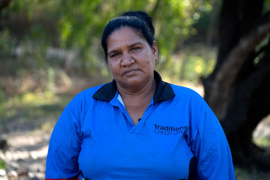 Adrianne Raggett wears a bright blue shirt and looks into the camera