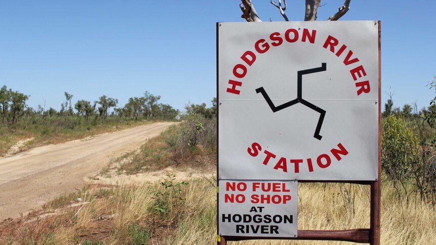 a sign for Hodgson River Station beside a dirt road.